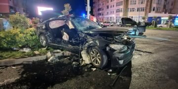 Patru tineri răniți, doi dintre ei extrăgându-se dintr-o mașină distrusă