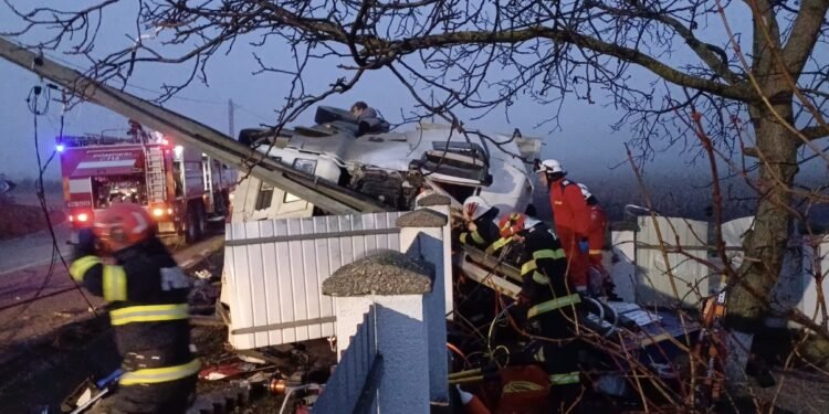 Camion răsturnat, șofer prins între fiare după ce a spulberat un stâlp și un gard