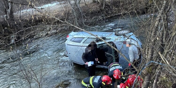Mașină căzută în albia râului